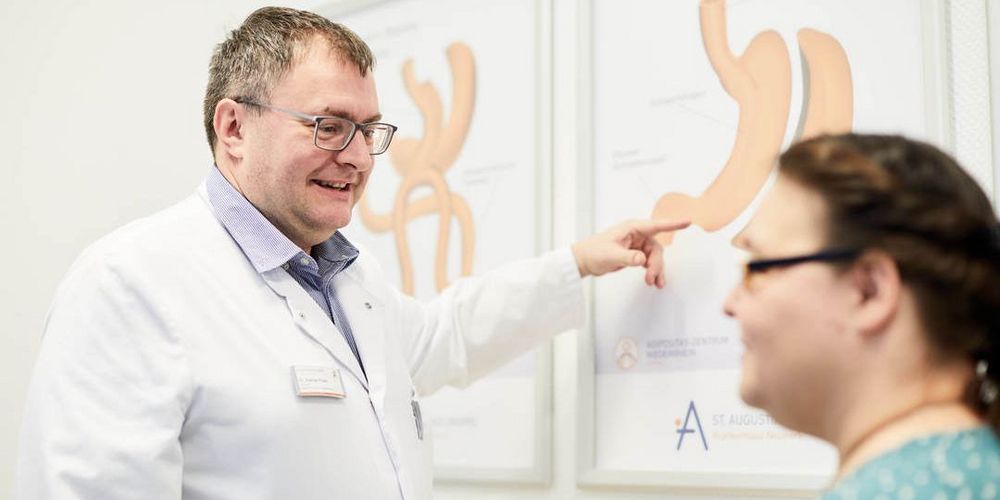 Ein Facharzt für Allgemein- und Viszeralchirurgie erklärt einer Patientin einen Eingriff im Magen-Darm-Trakt.